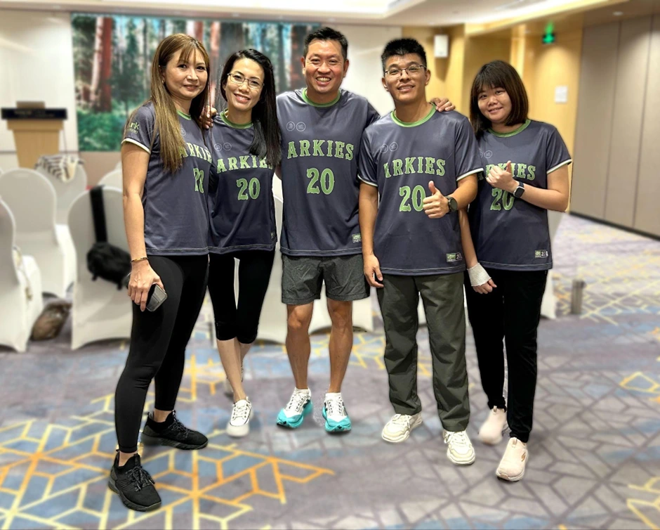 A group of people posing for a photo wearing arkies t-shirt